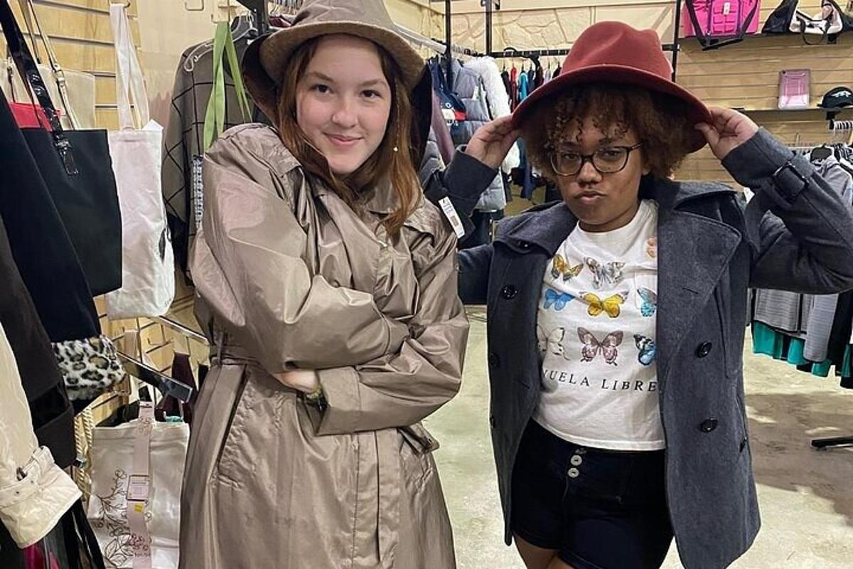 two women standing next to each other in a clothing store