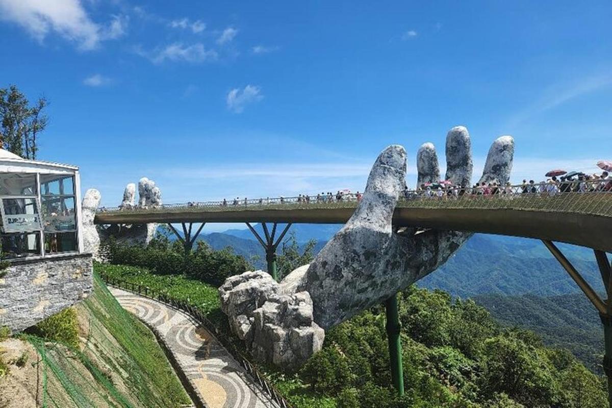 una estatua de una mano que se extiende sobre un puente