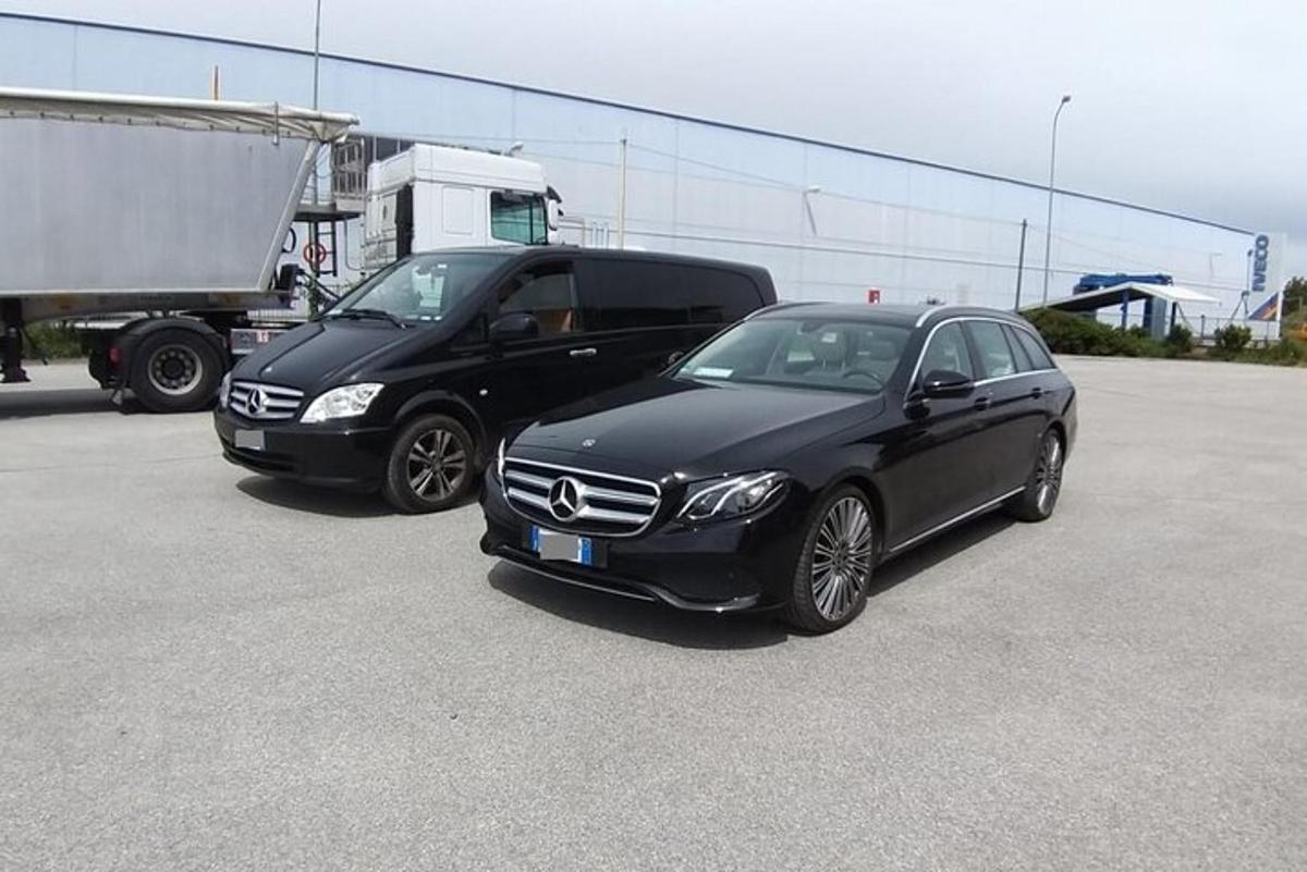 two black cars parked next to a truck