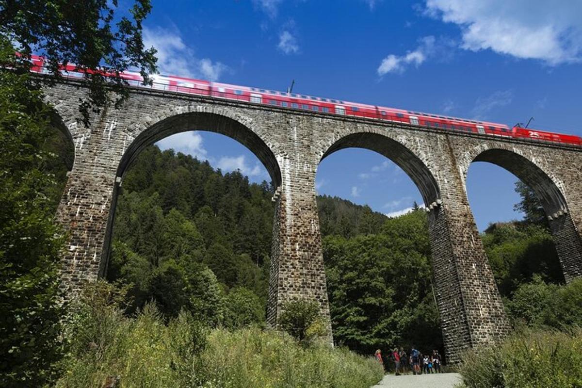 a train crossing a stone bridge with a train on it