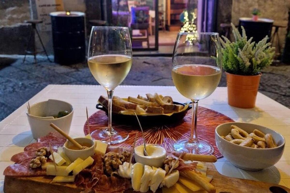 uma mesa coberta com duas taças de vinho e queijo