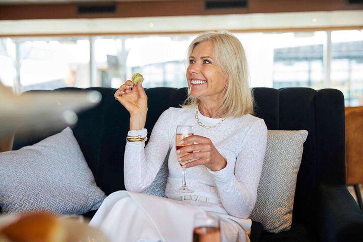 en kvinde sidder på en sofa med et glas vin