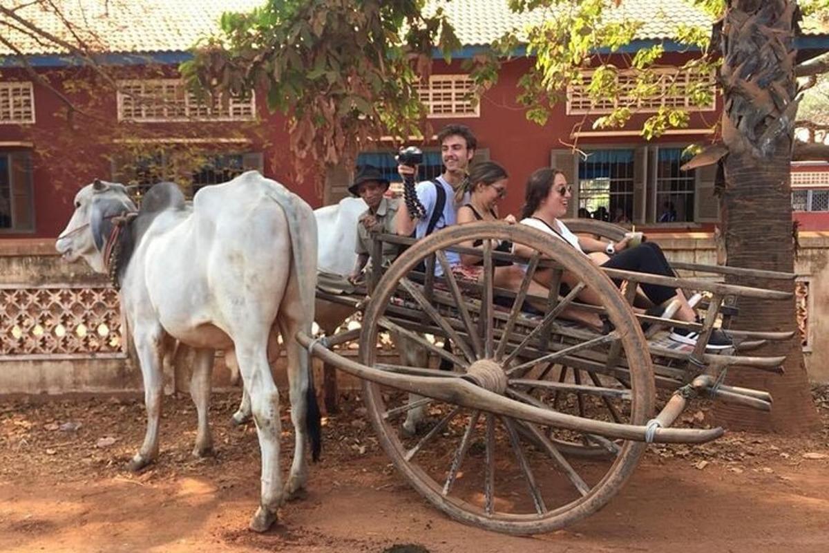 una vaca tirando de un carro con un grupo de personas