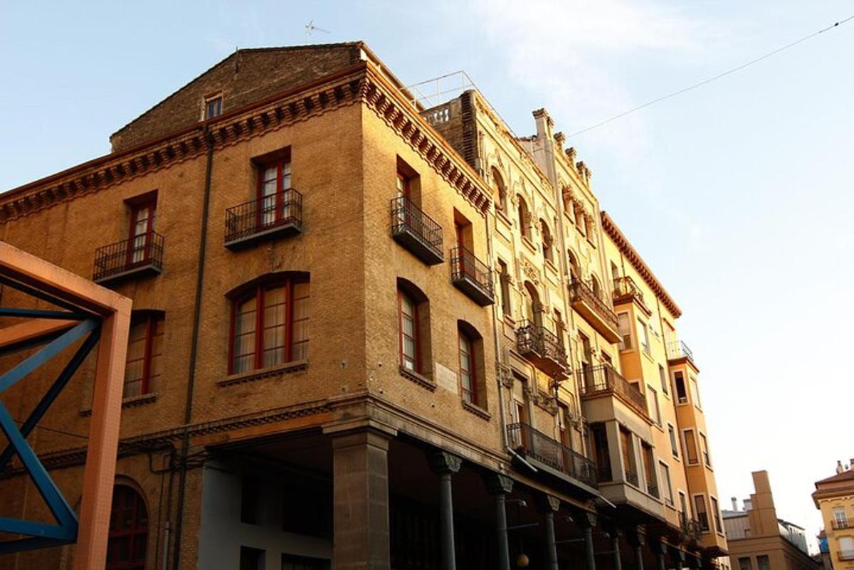 ein großes Backsteingebäude mit Fenstern an einer Straße