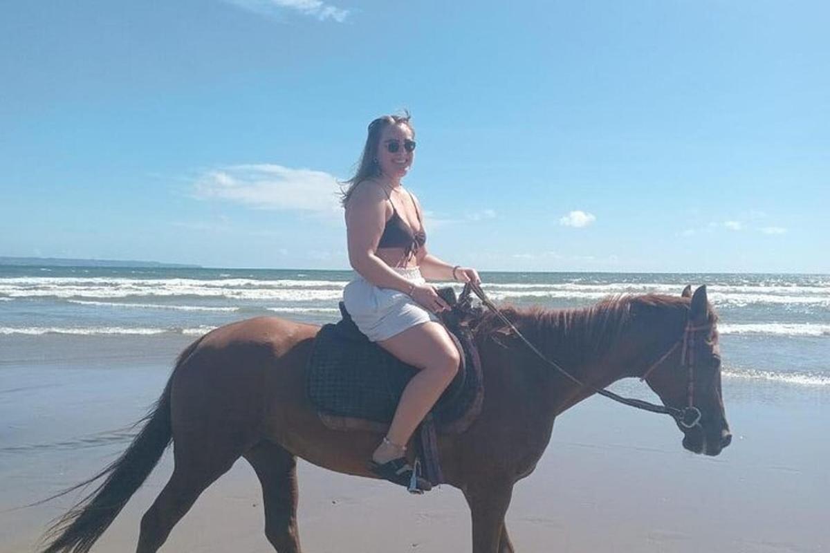 una donna a cavallo sulla spiaggia