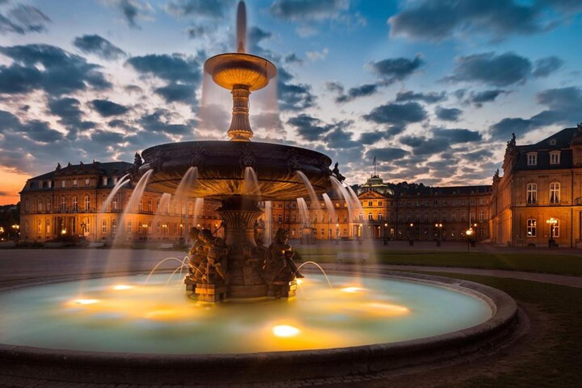 a fountain in front of a building at night