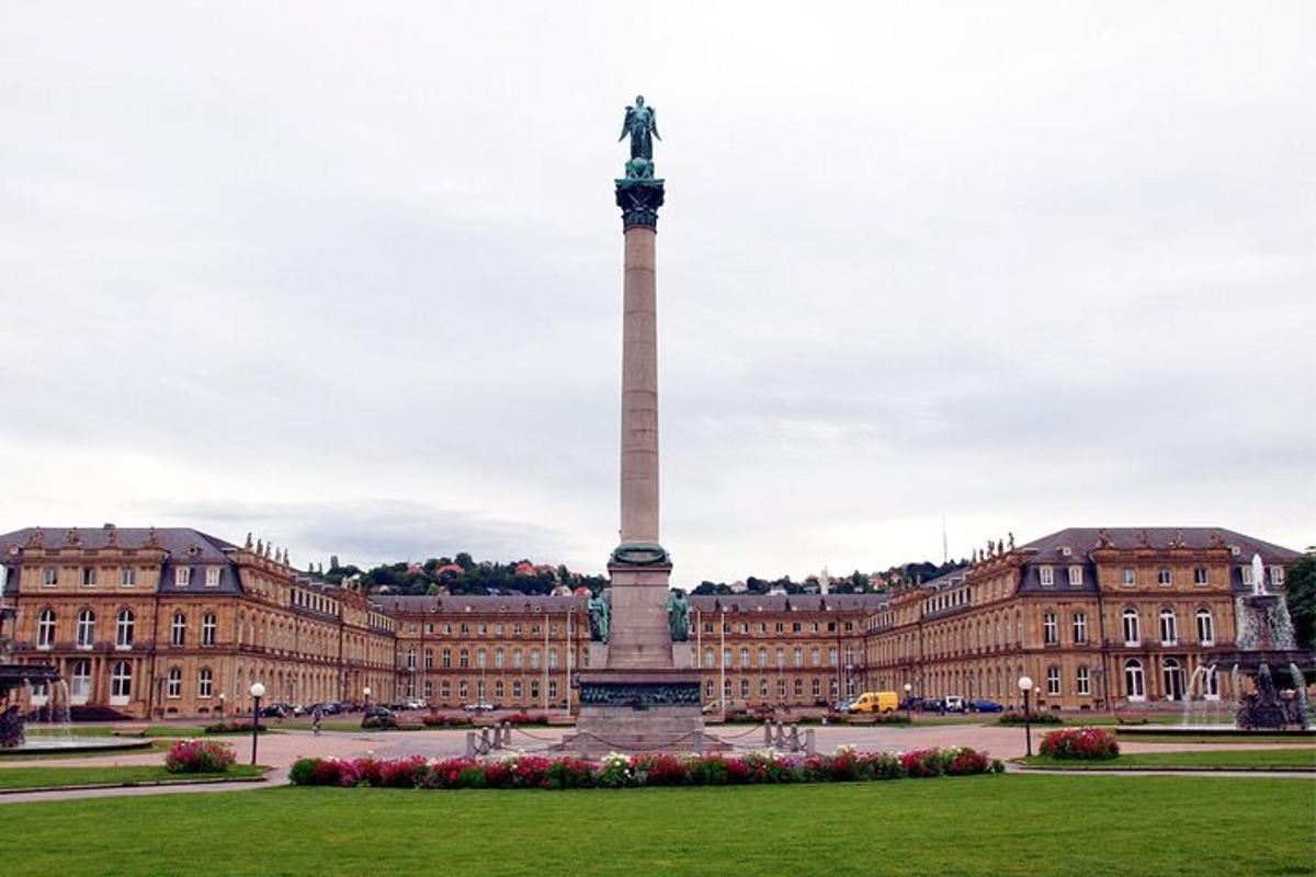 a statue in front of a large building with a monument