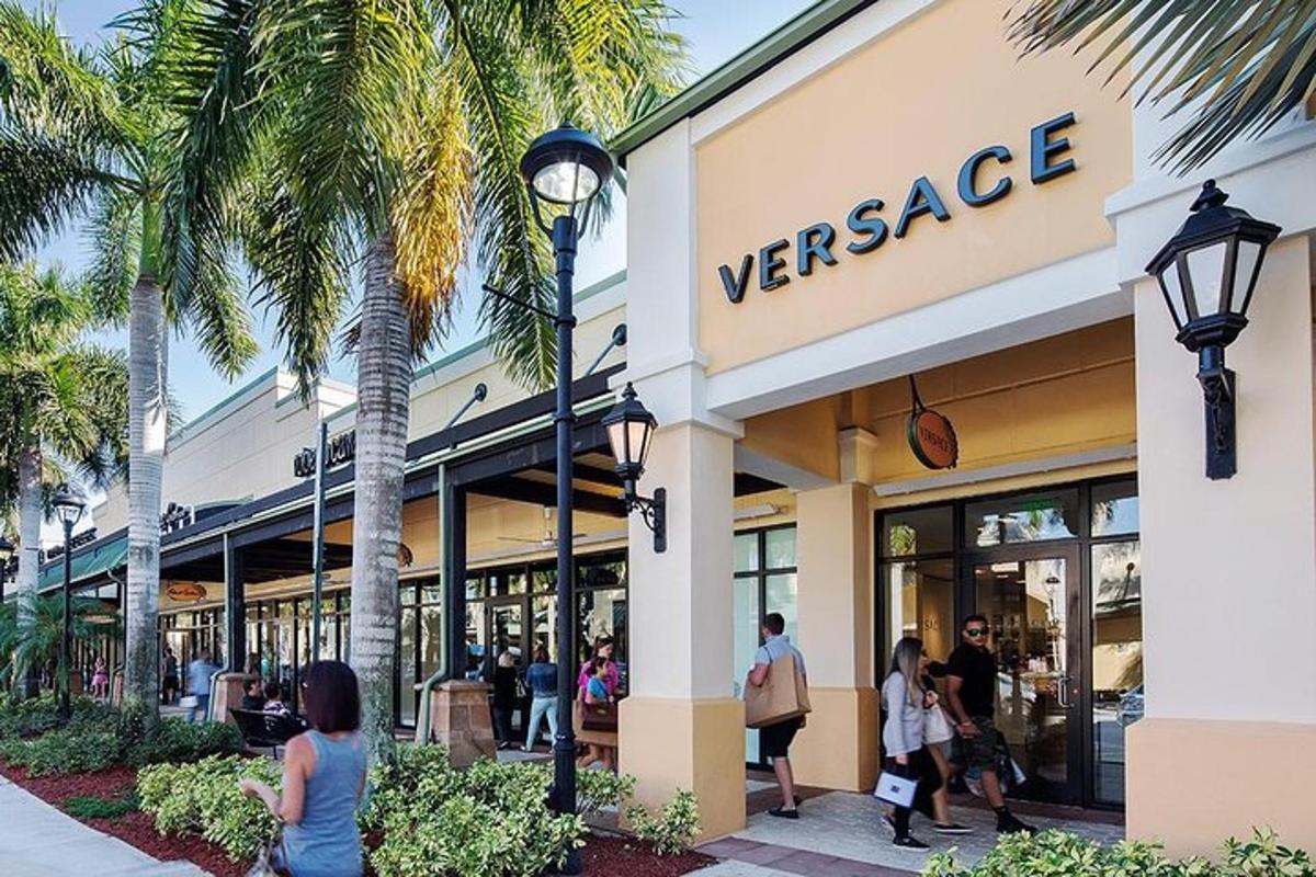 Inimesed jalutavad palmipuudega Versace'i poe ees