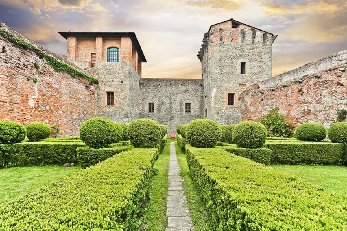 Un antiguo castillo con arbustos delante.
