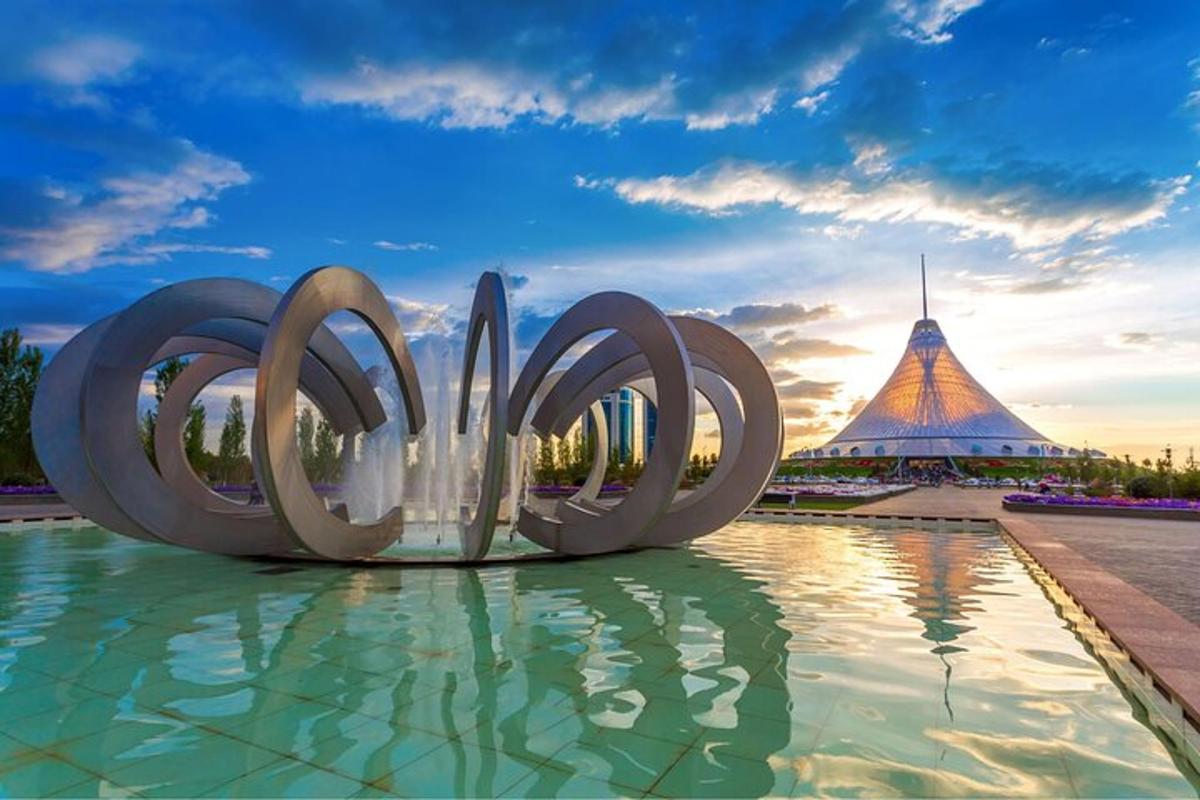 a view of a fountain with a pyramid in the background