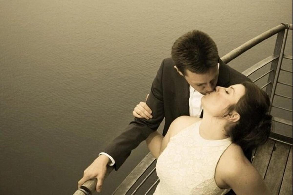 sepasang pengantin berciuman di dermaga