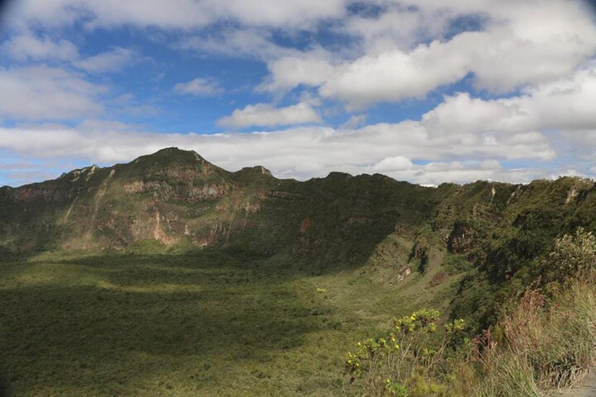 a view of a mountain with a blue sky and clouds
