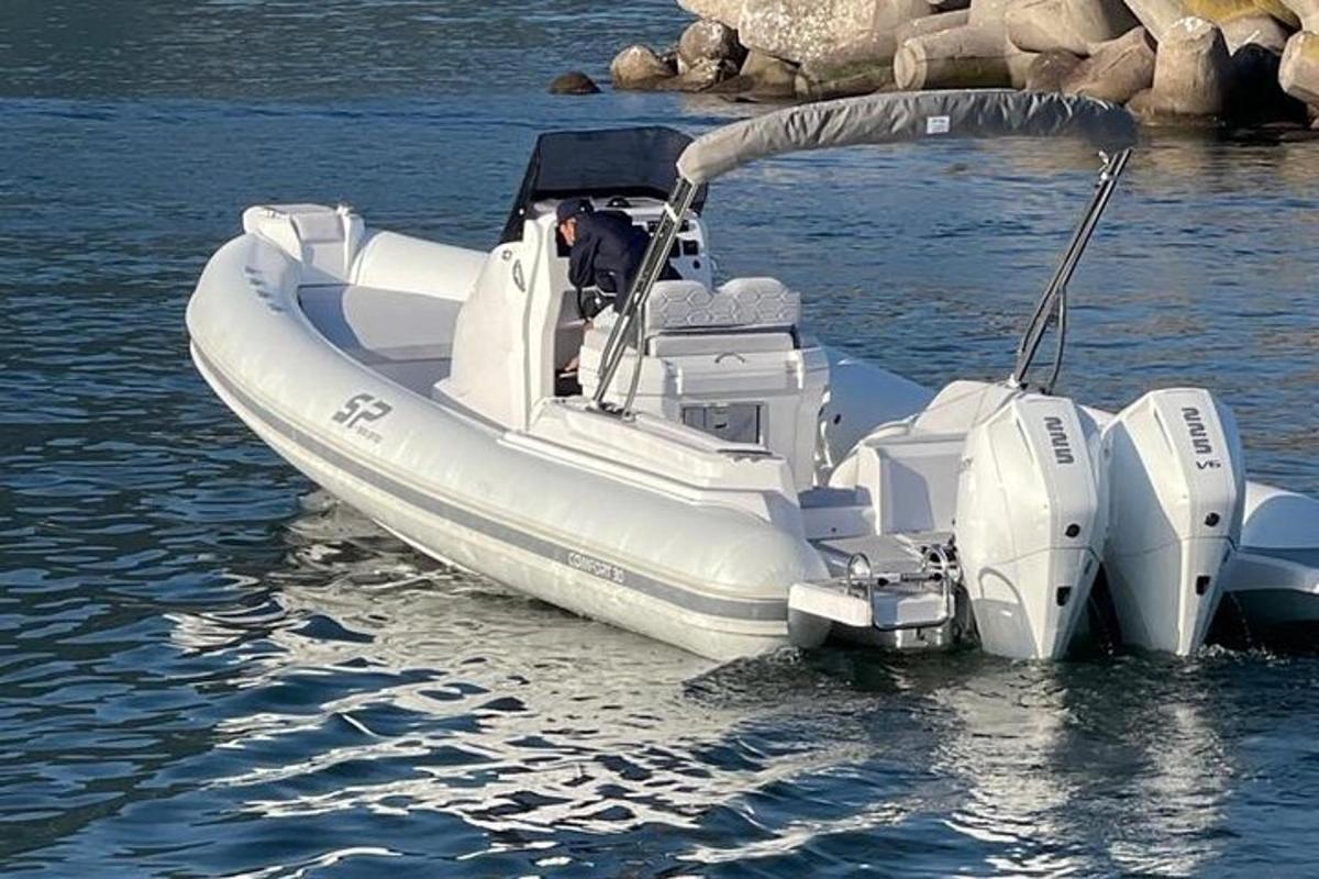 um barco branco na água com um cachorro dentro