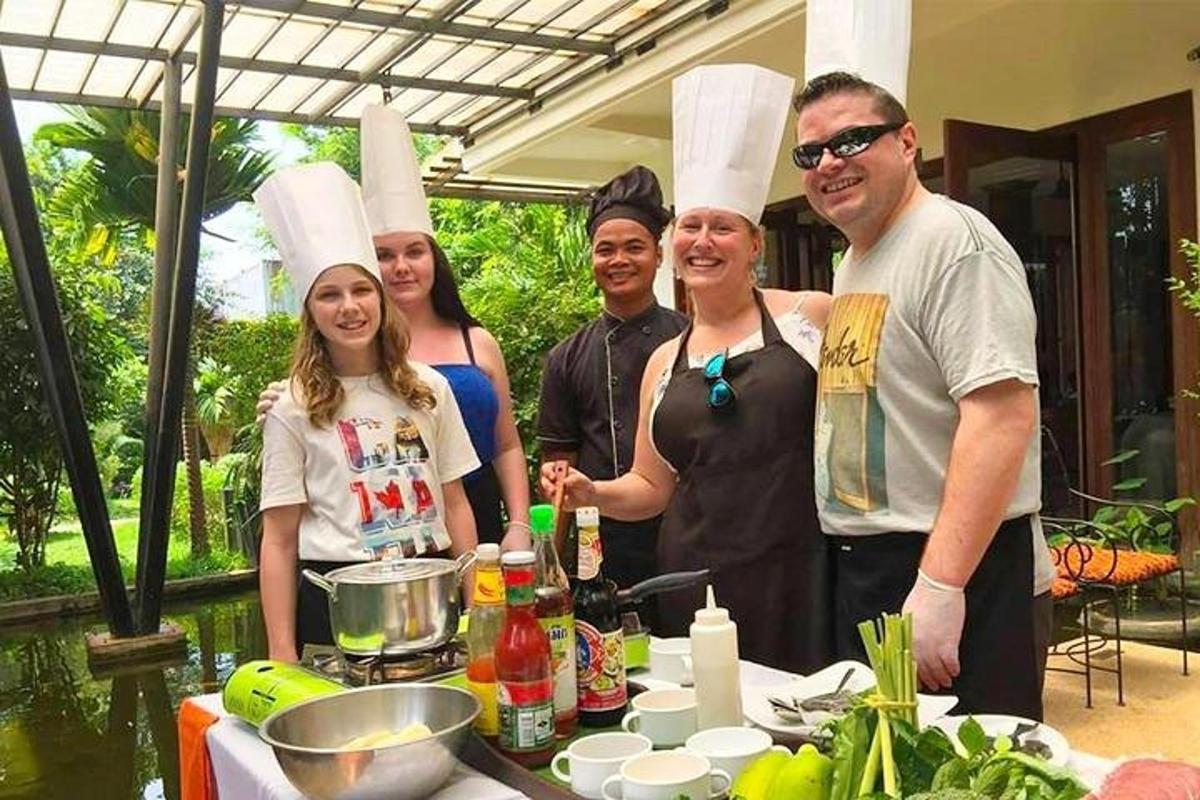 isang grupo ng mga tao na nakasuot ng mga chef na sumbrero na nakatayo sa tabi ng isang mesa