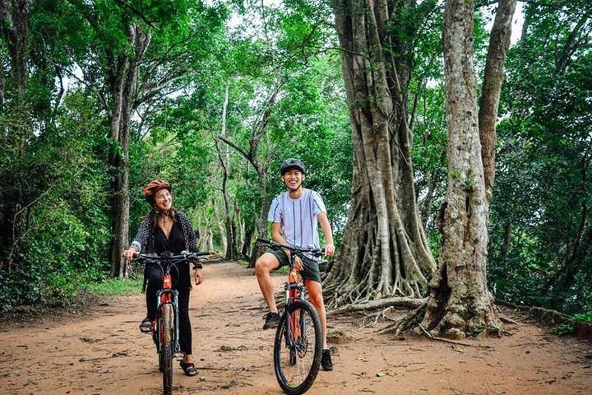 dua orang menunggang basikal melalui jalan tanah