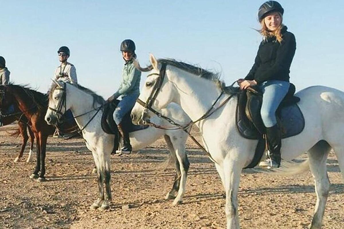 cilvēku grupa, kas jāj ar zirgiem pa lauku