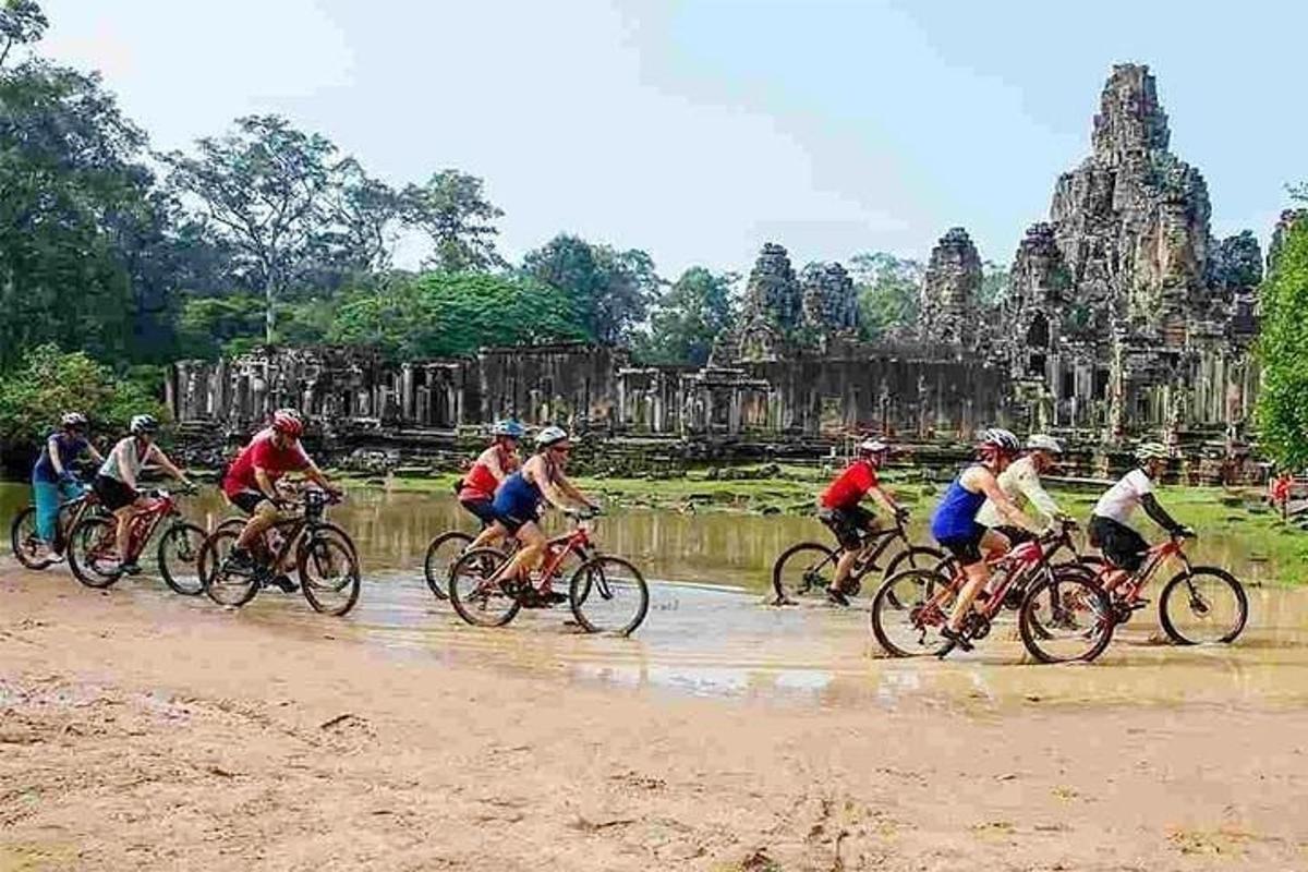 sekumpulan orang menunggang basikal di hadapan kuil
