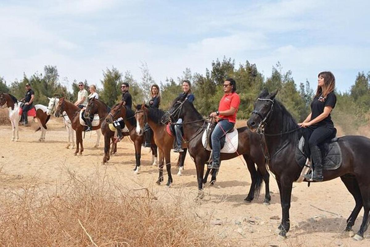 مجموعة من الأشخاص يركبون الخيول على طريق ترابي