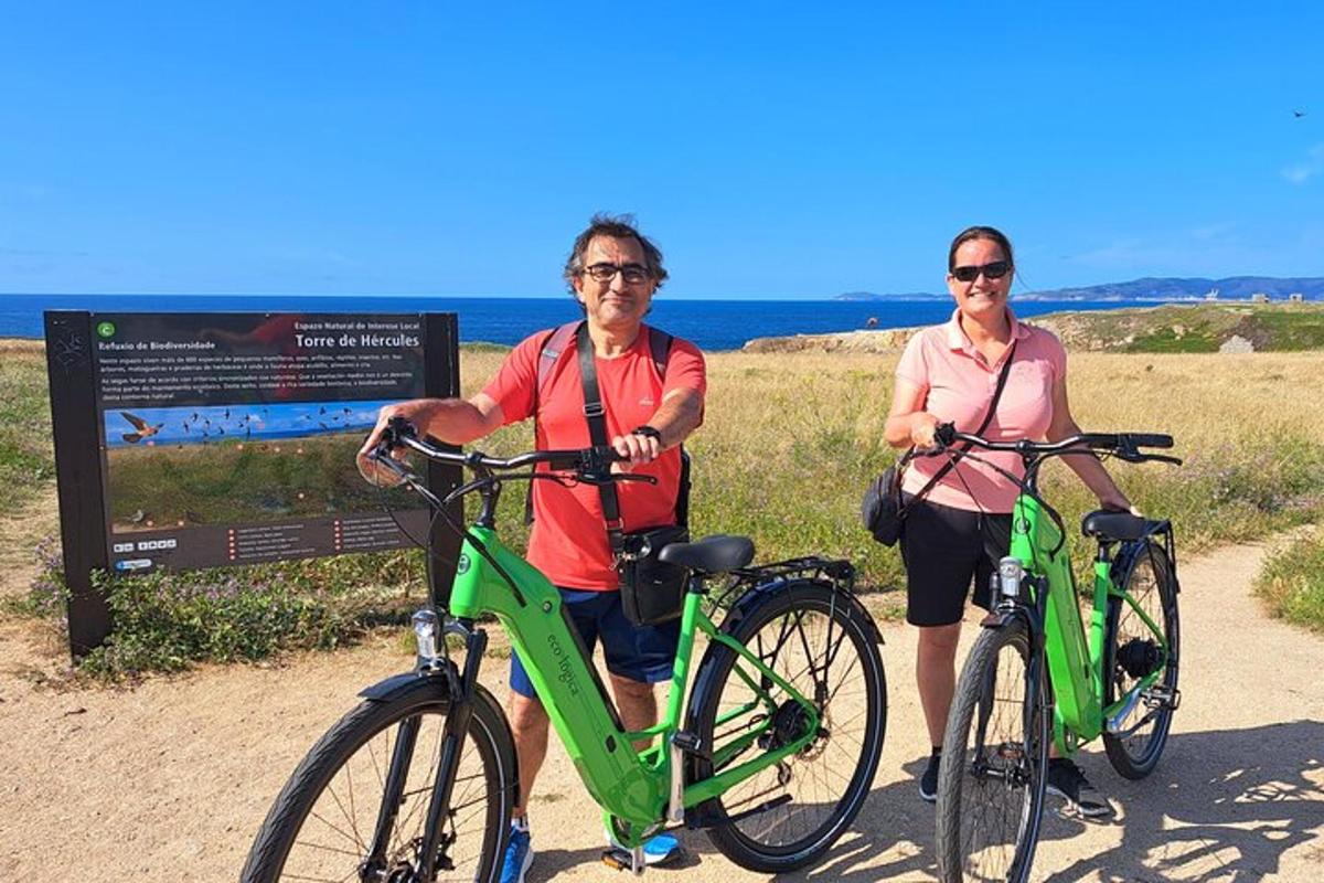 two people standing with their bikes in front of a sign