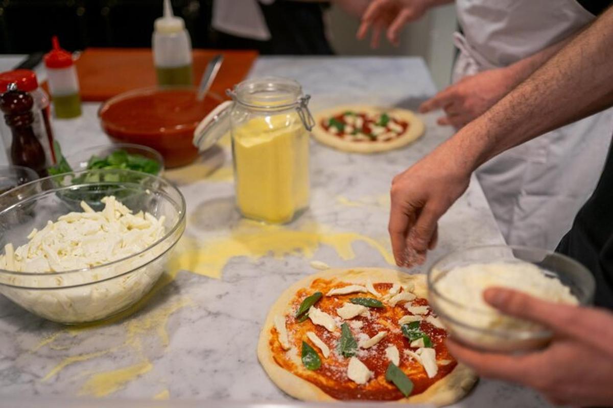 sekumpulan orang membuat pizza di atas meja