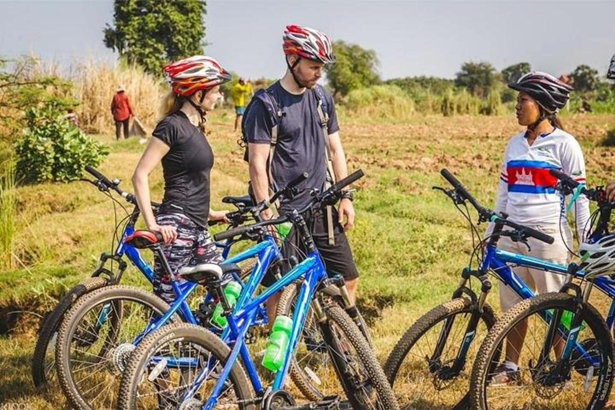 un grup de oameni care stau cu biciclete pe un câmp