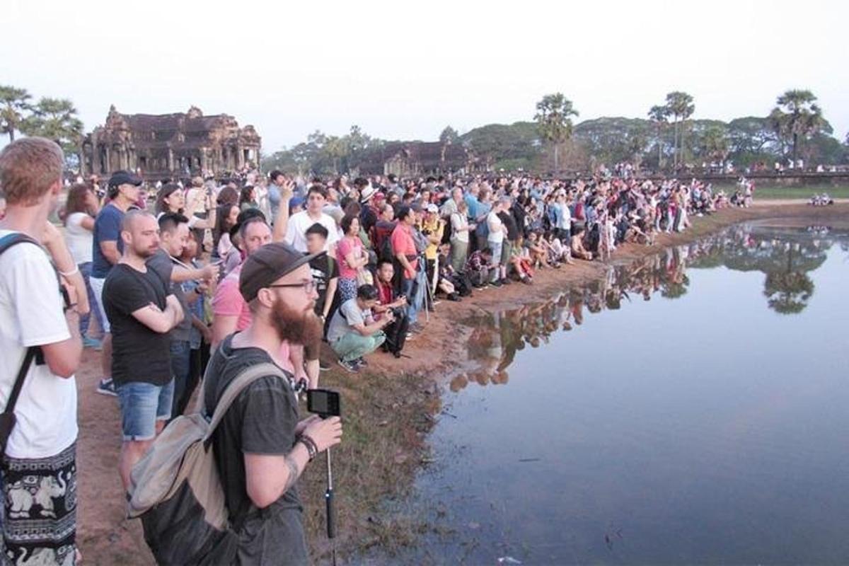 una gran multitud de persones dempeus al costat d'una massa d'aigua