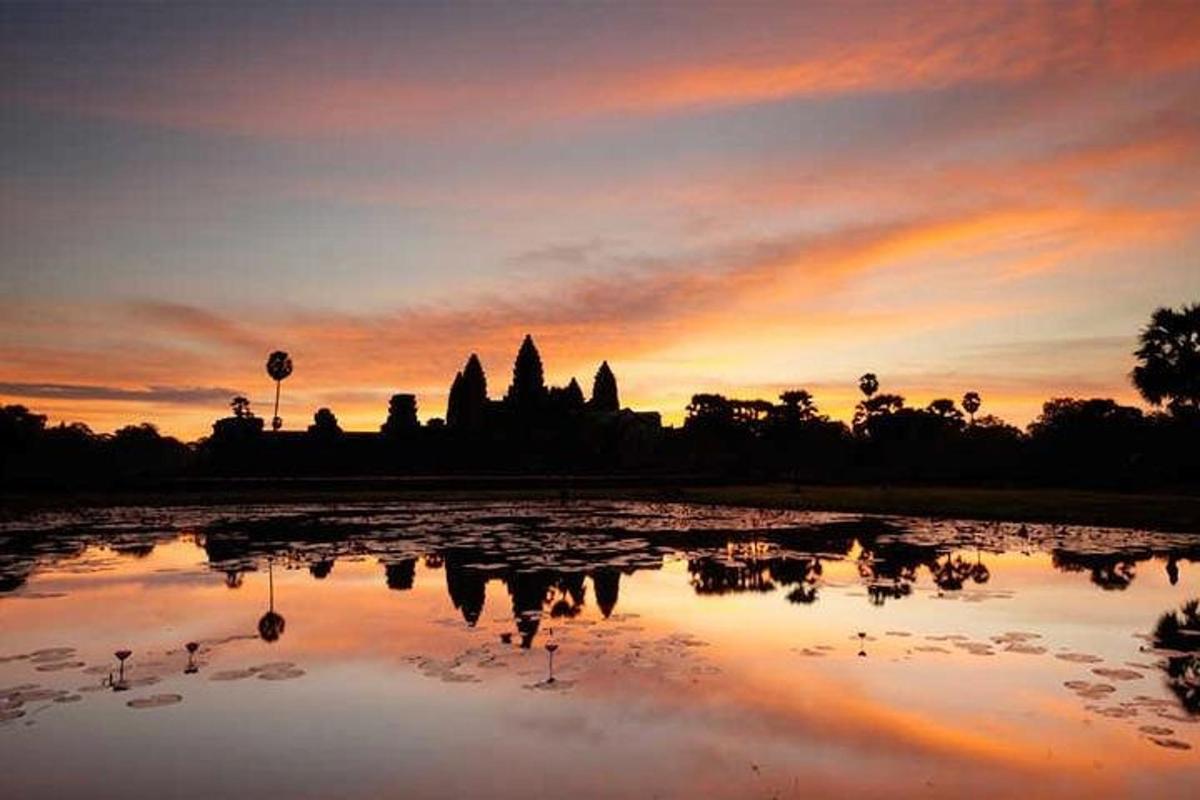 una posta de sol amb el reflex d'un temple en un estany