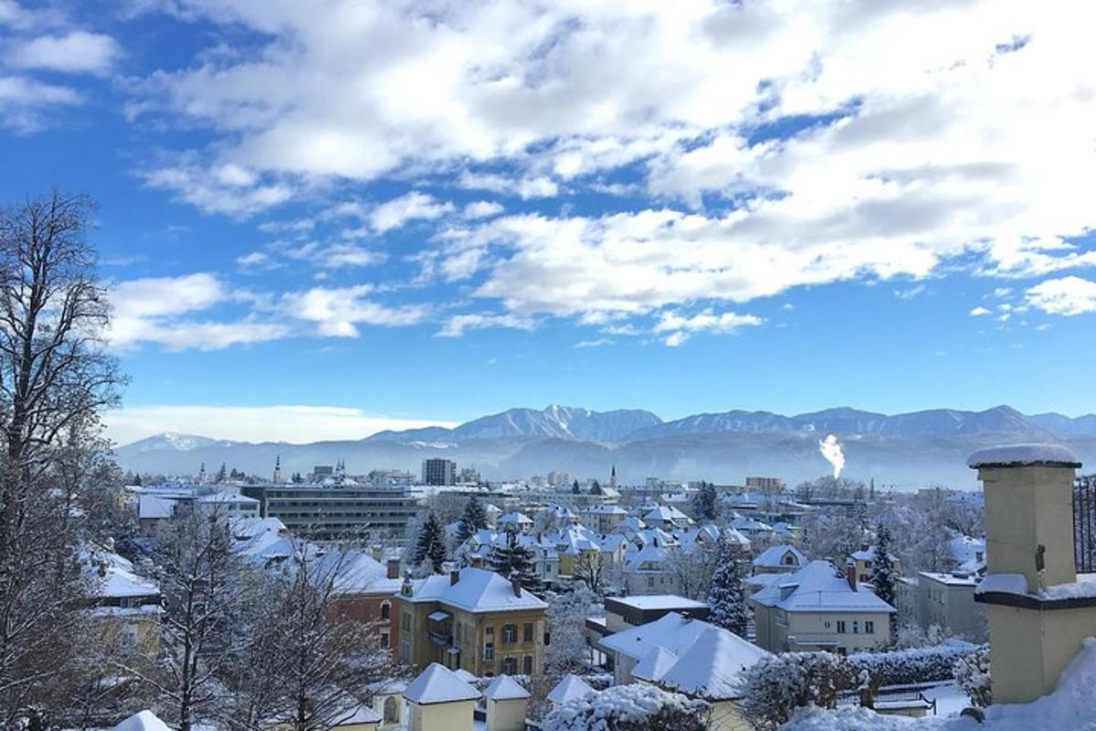a city covered in snow with mountains in the background