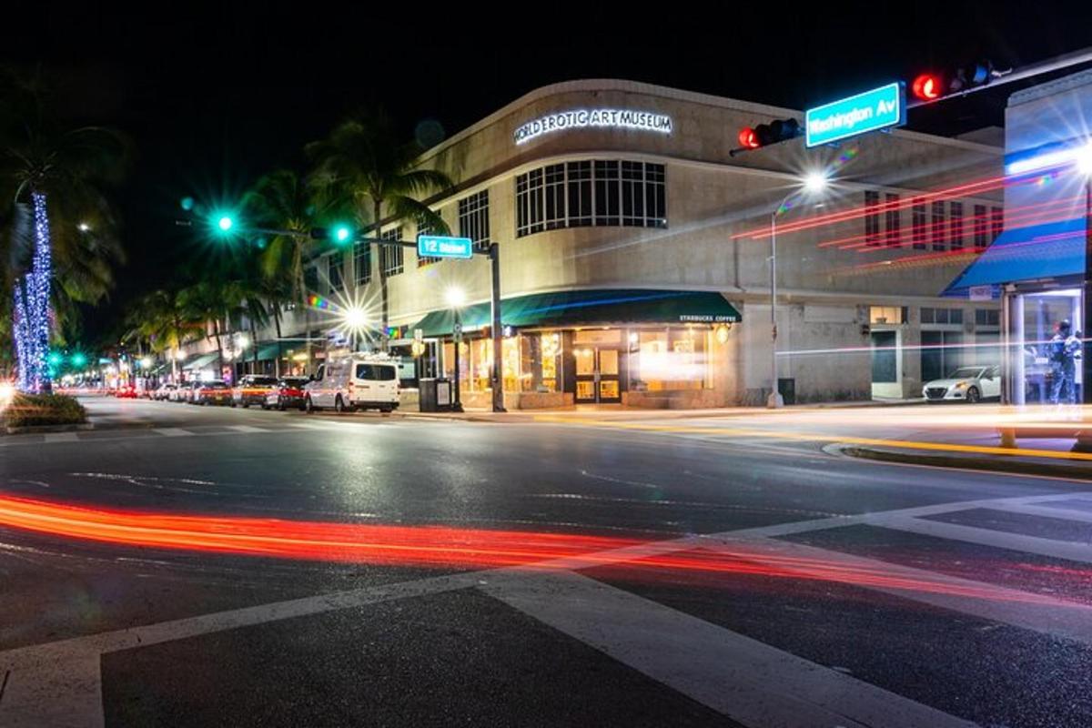 Una calle de la ciudad por la noche con semáforos y un edificio.