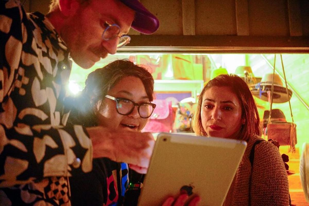a man and two women looking at a laptop computer