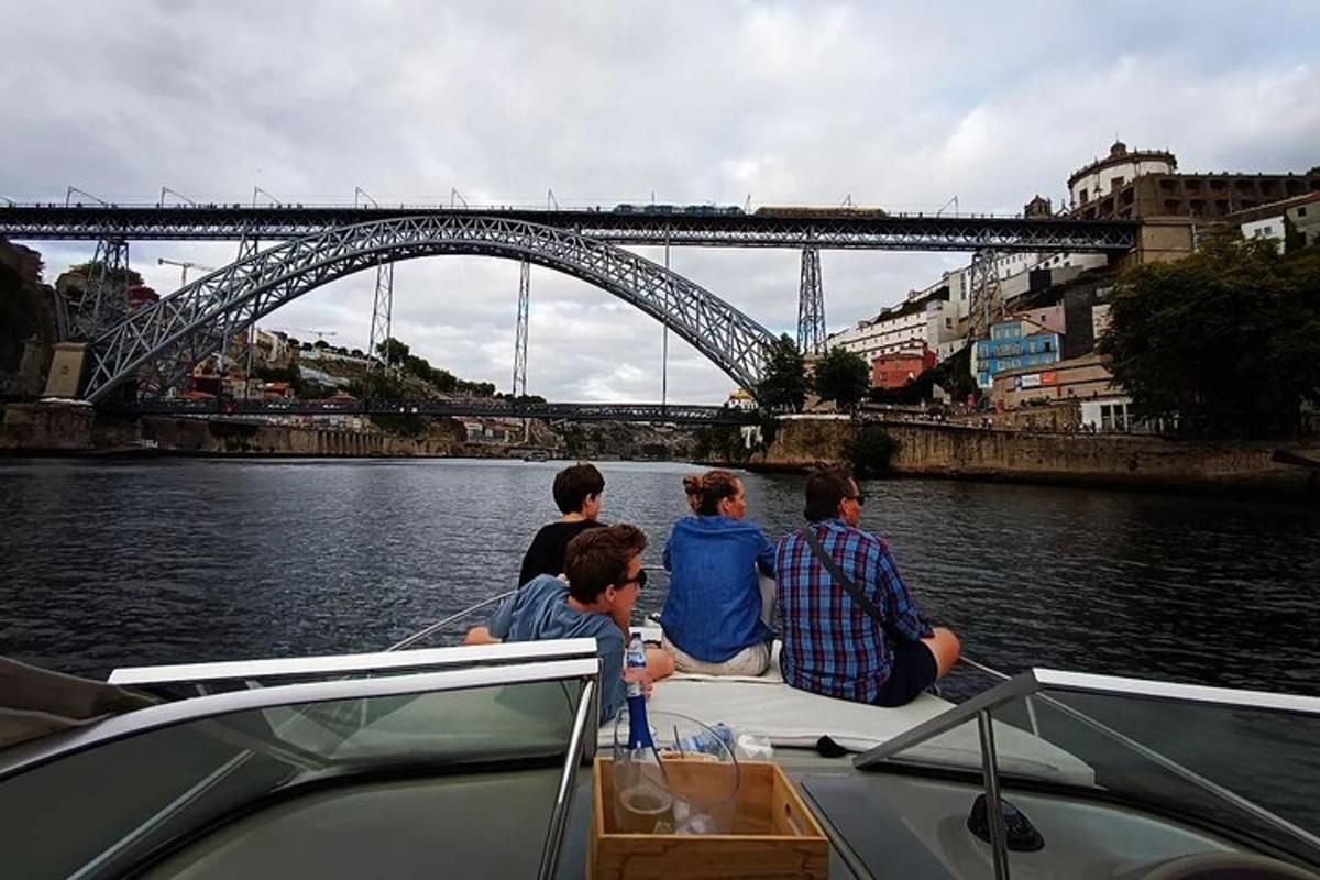um grupo de pessoas sentadas em um barco na água com uma ponte