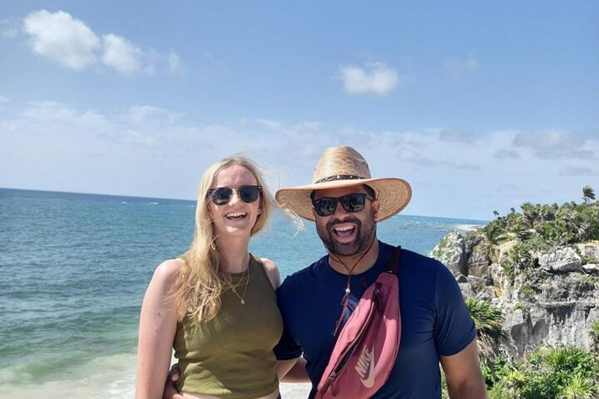 a man and woman standing next to the ocean