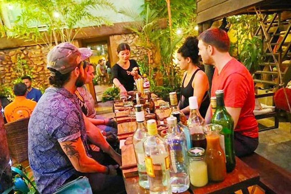 um grupo de pessoas sentadas ao redor de uma mesa com bebidas