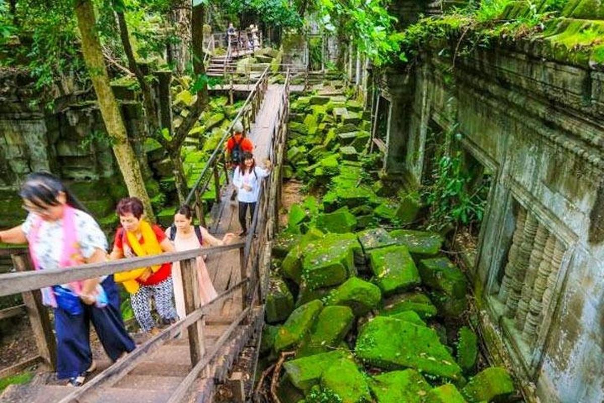 un gruppo di persone in piedi su un ponte in uno zoo
