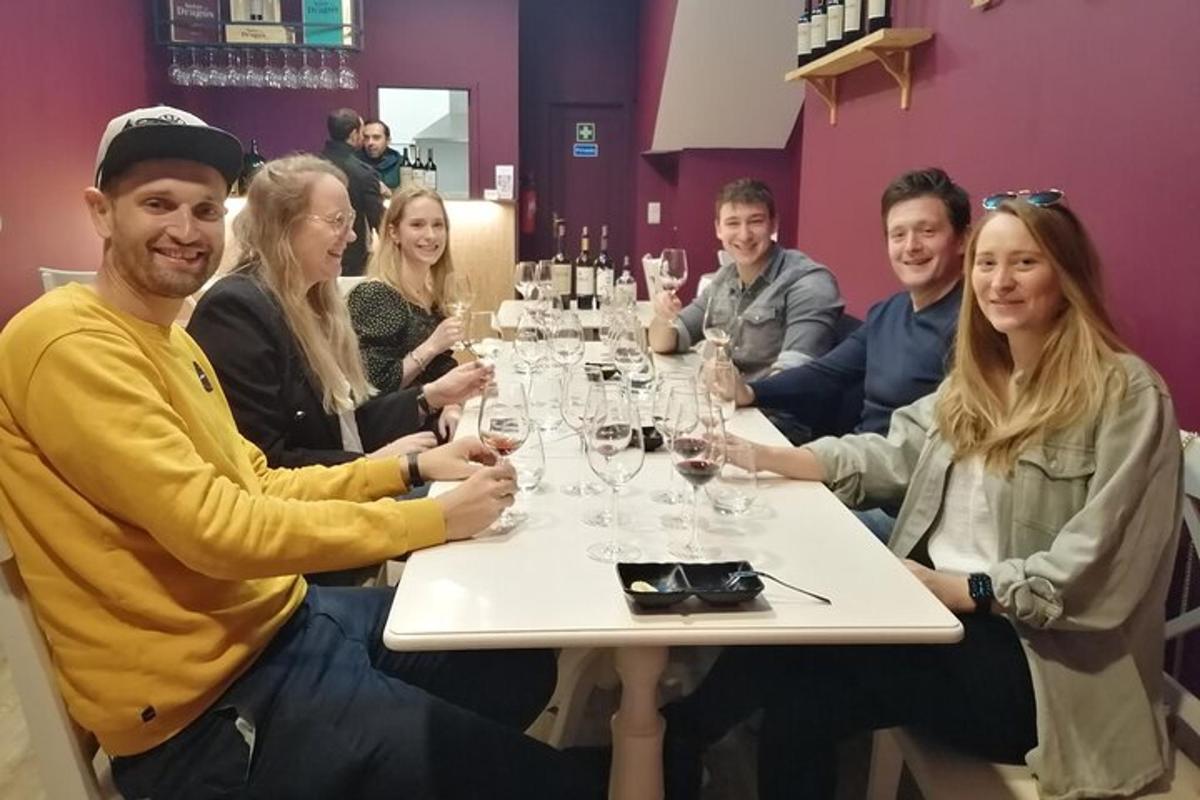 un gruppo di persone sedute attorno a un tavolo con bicchieri di vino