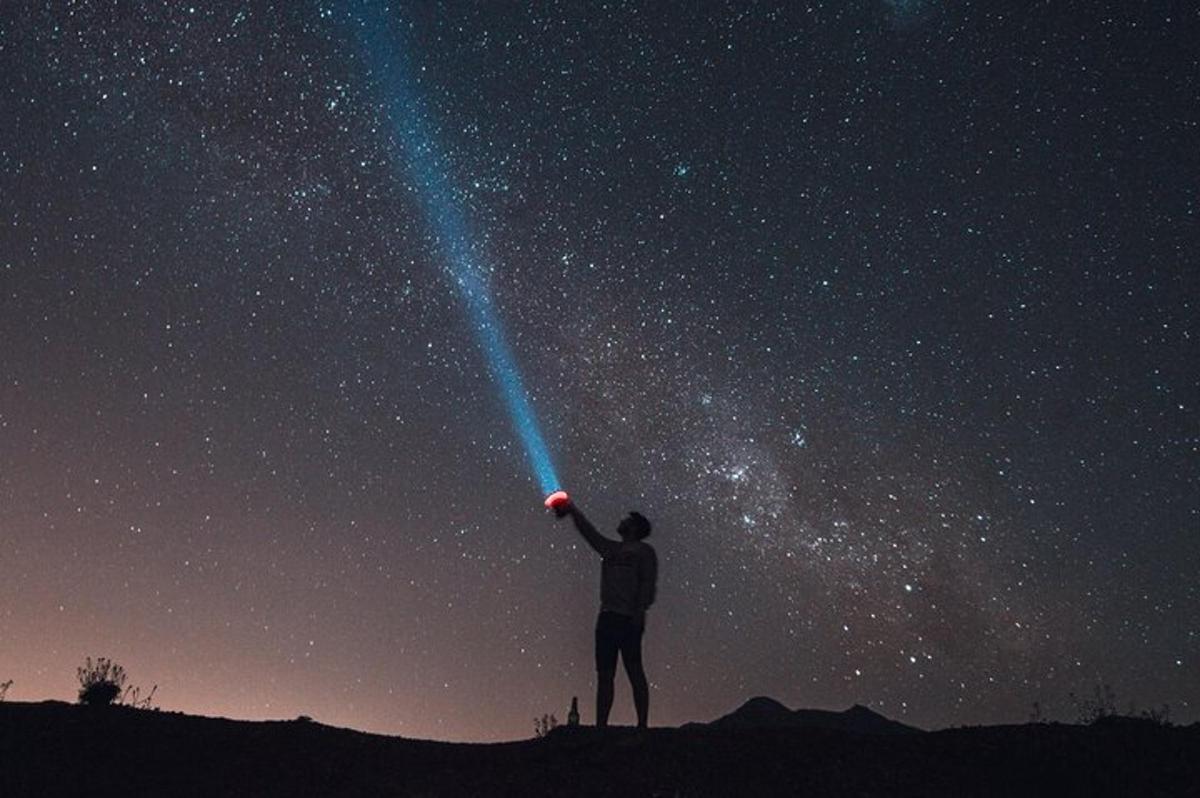 一个男人站在山上仰望星空