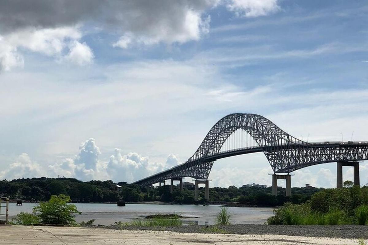 een grote brug over een rivier met een bewolkte lucht