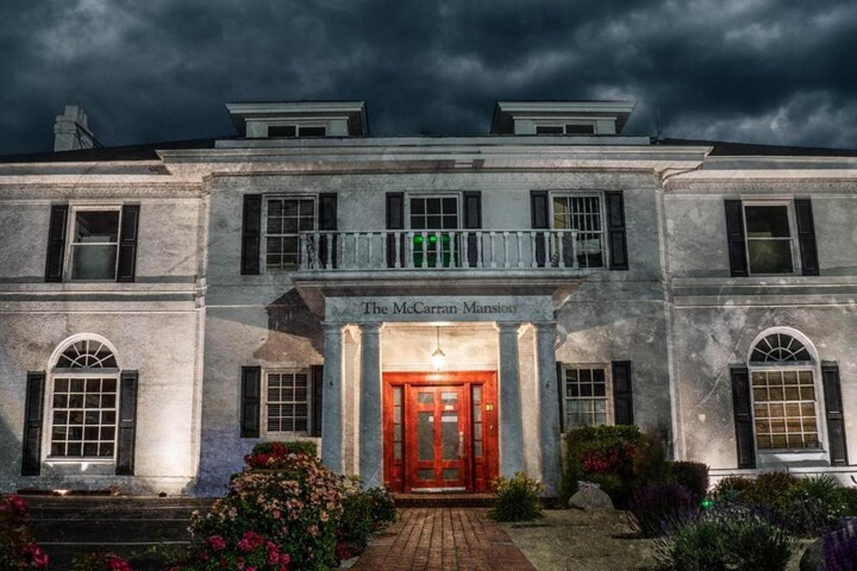 a white house with a red door and a cloudy sky