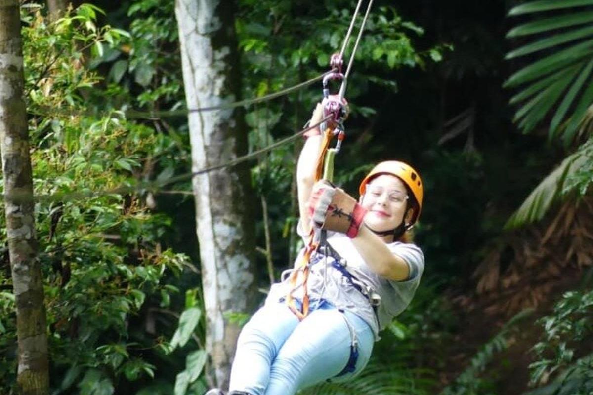 a woman on a zip line in the jungle