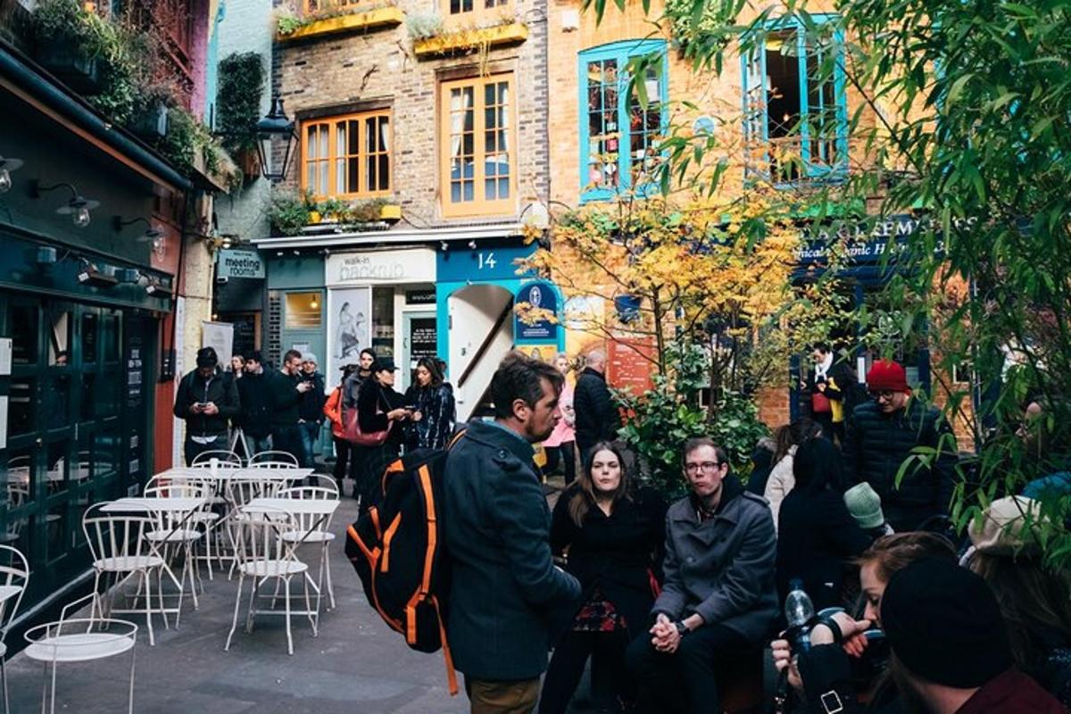 μια ομάδα ανθρώπων που περπατούν σε έναν δρόμο με τραπέζια και καρέκλες