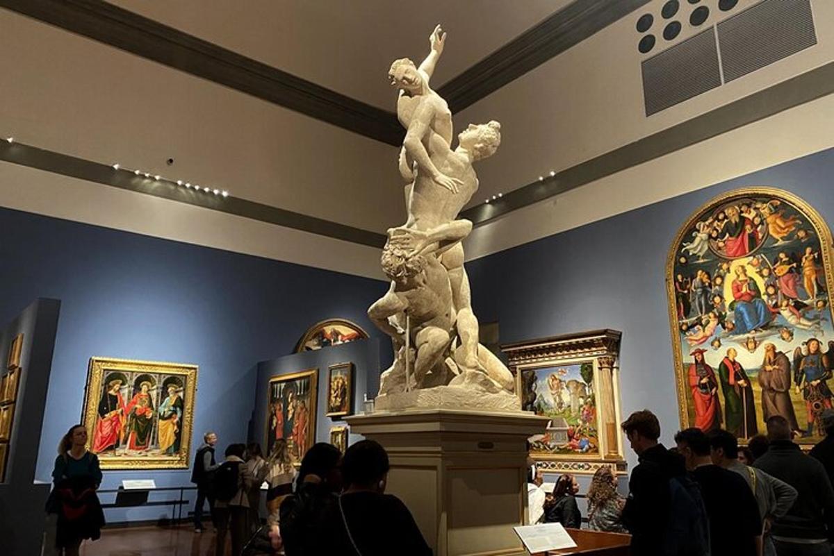 a statue in a museum with people looking at paintings