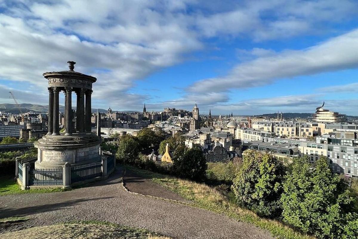 a monument on a hill with a view of a city