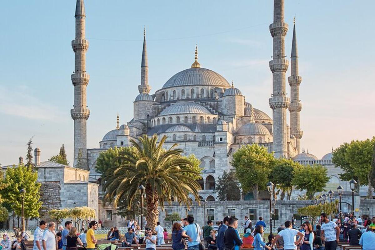 un gruppo di persone in piedi davanti a una moschea