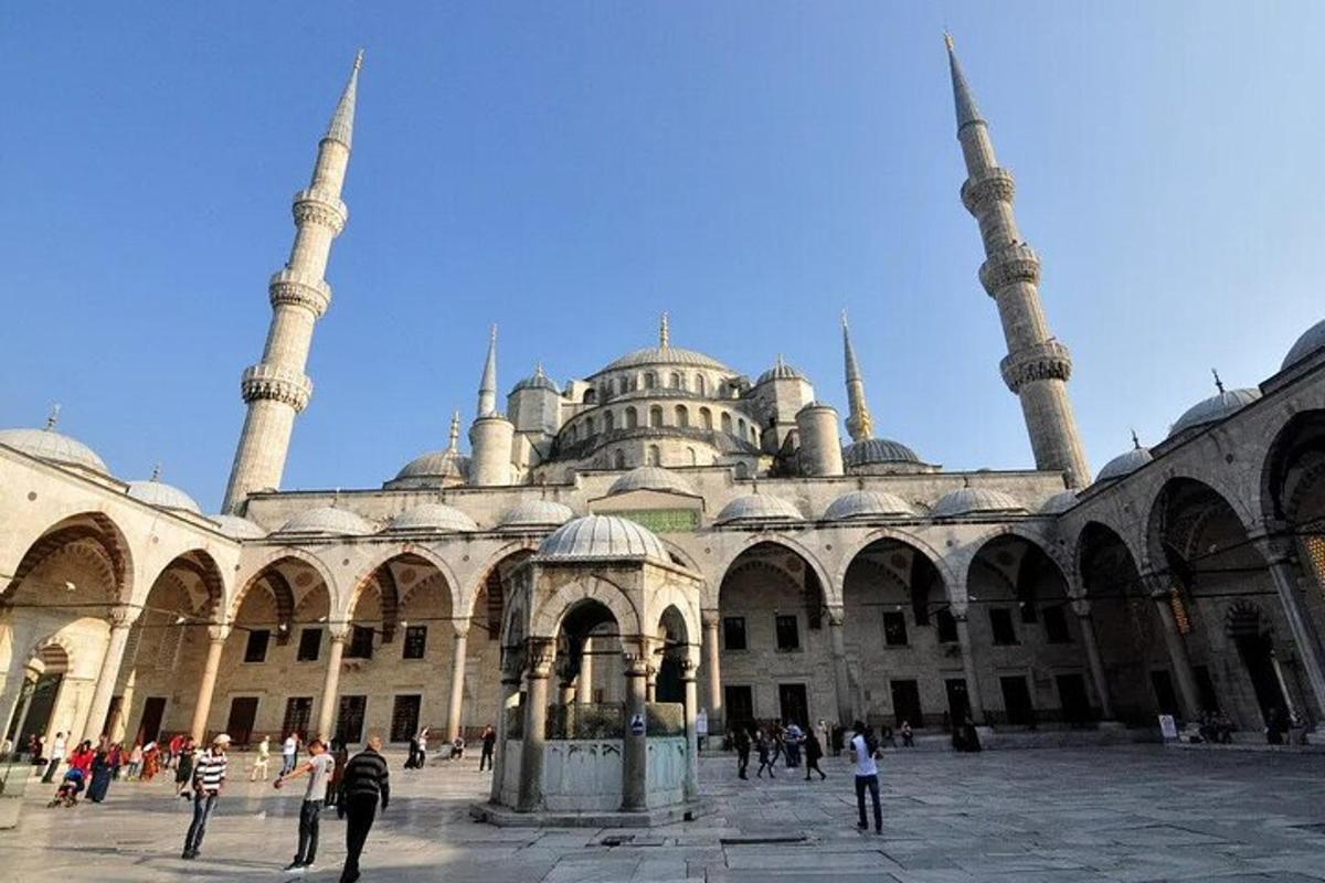 un grande edificio con due moschee e persone in piedi intorno ad esso