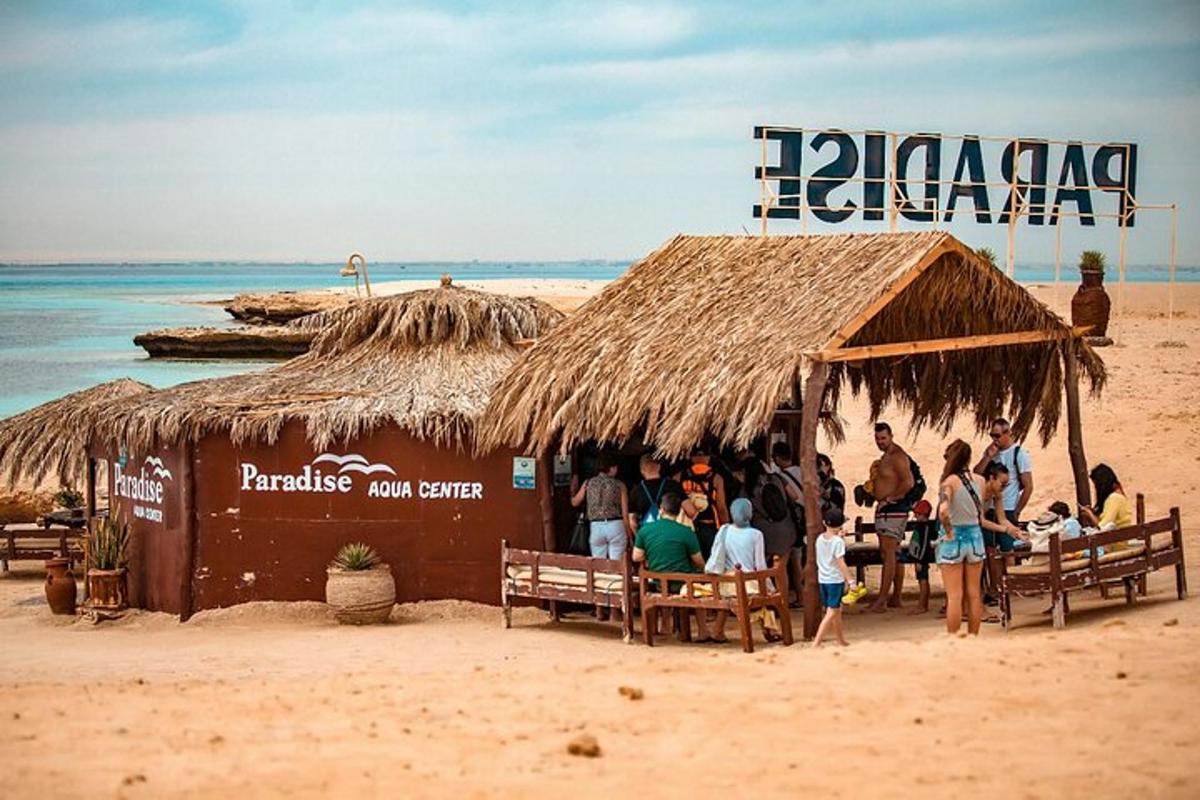 Un grupo de personas de pie en un bar en la playa.