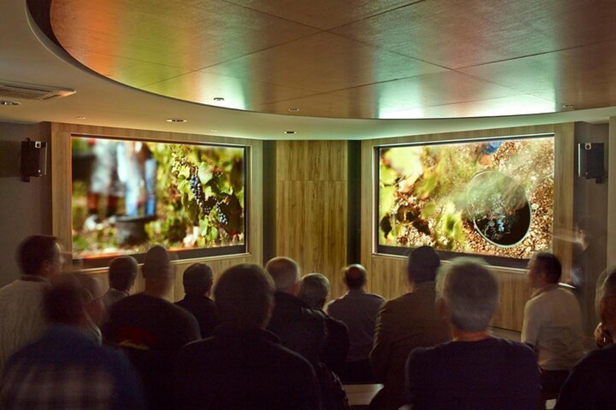 a group of people sitting in a room looking at paintings