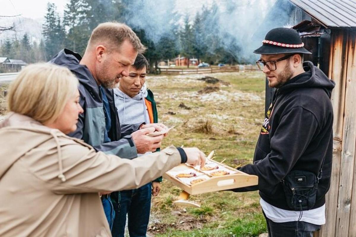 a group of people standing around a woman holding a box of hot dogs