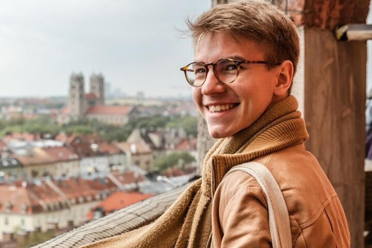 un tânăr purtând ochelari stând pe o cornișă
