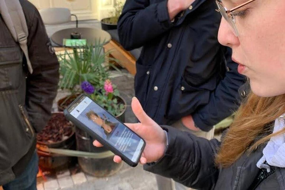 žena držící v ruce mobilní telefon