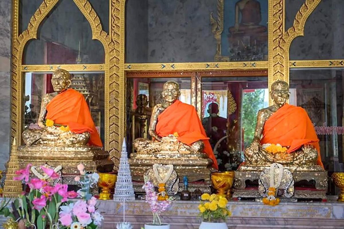tre statue di monaci seduti in un tempio